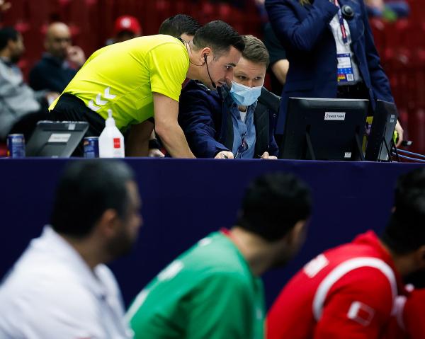 Die Schiedsrichter beim Spiel USA gegen Bahrain beim Videobeweis vor der Blauen Karte
